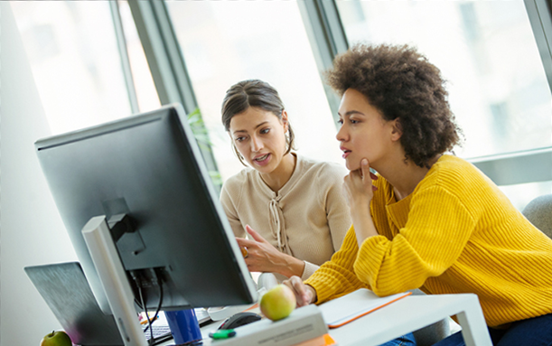 Two women reviewing software